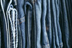 Stack of blue jeans as background, space for text