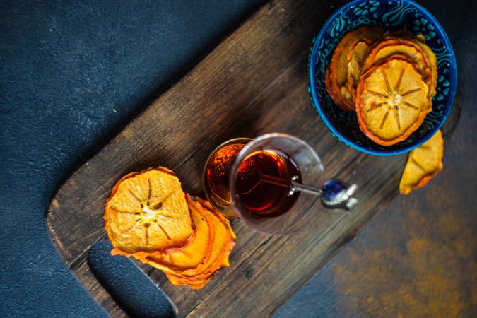 Top view of dried persimmon slices surrounding Turkish tea