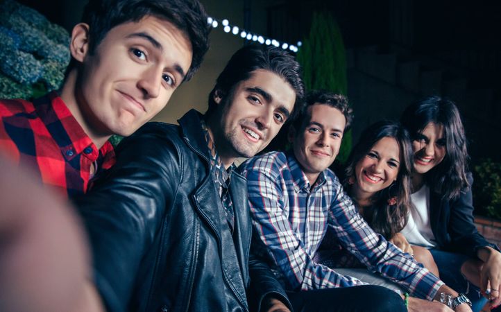 Happy friends taking selfie at a party