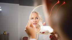 A beautiful woman watches herself in a mirror at beauty salon