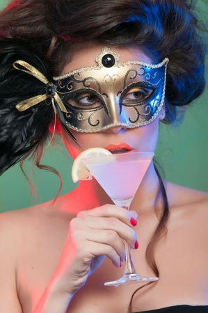 Woman in mask holding glass of drink