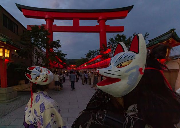 Two people wearing Inari-Fox mask celebrating Motomiya-sai festival in Kyoto, Japan