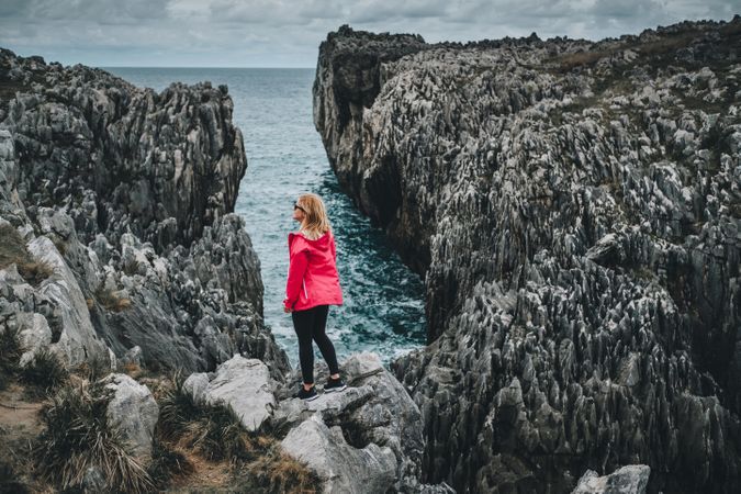 Female standing on cliff and contemplating