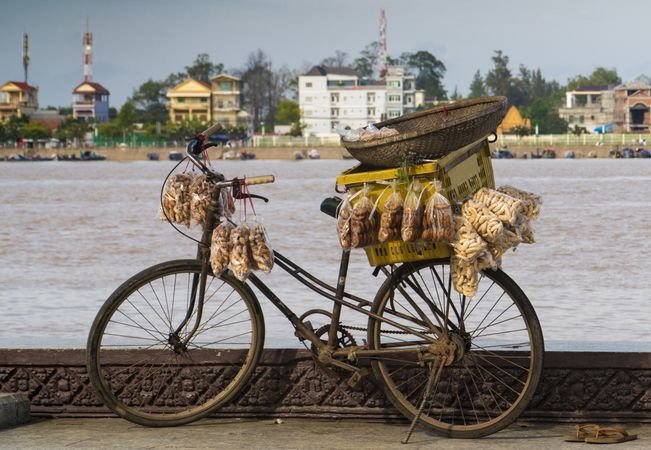 Aged bicycle with food for sale on coast