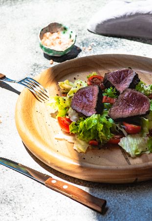 Steak salad with fresh lettuce on table