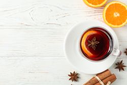 Mulled wine, orange and cinnamon on wooden background, top view