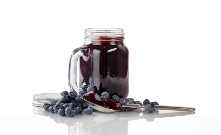 Fresh blueberry jam and berries with glass jar isolated
