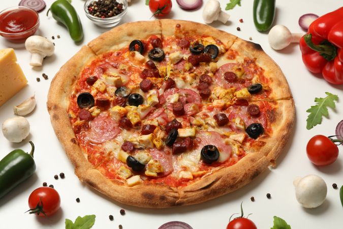 Pizza with meat and ingredients on neutral background