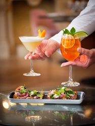 Crop waiter serving appetizers and cocktails