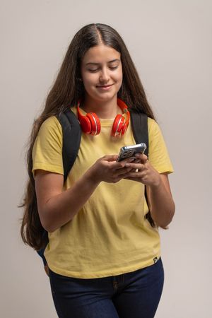 A smiling young student using her smartphone, texting or Browse social media.