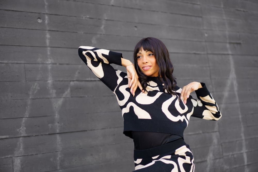 Trendy woman posing outside grey wall