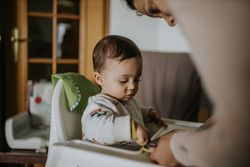 Mother leaning down to her son in a high chair