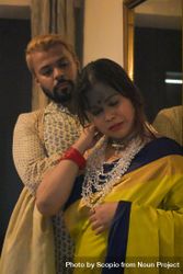 Woman in yellow sari standing in front of man indoor 5QYXm5