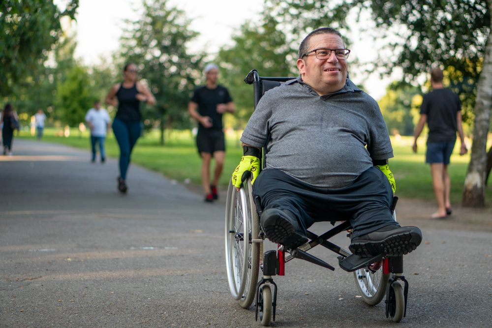 Man riding through park in wheelchair
