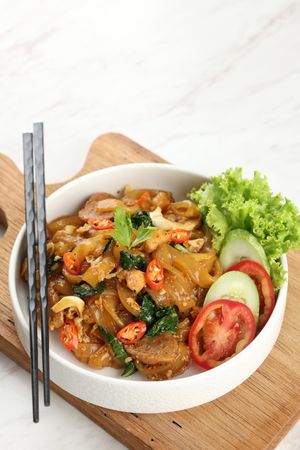 Kwetiaw or Kwetiau, Fried Rice Flat Noodles with Chicken, Meatballs, and Various Vegetables.
