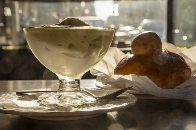 Layered Sicilian granita with pistachio and almond flavors served with brioche in morning sunlight