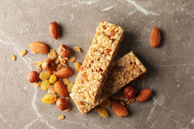 Tasty granola bars on gray background, top view