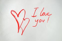 Valentine Day holiday card concept with "I love you" and two hearts drawn in red