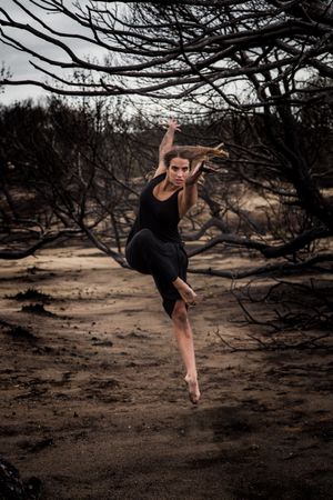 Woman dancing between dry trees