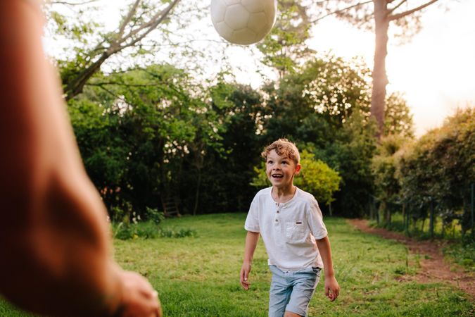Cute little boy playing football with his father