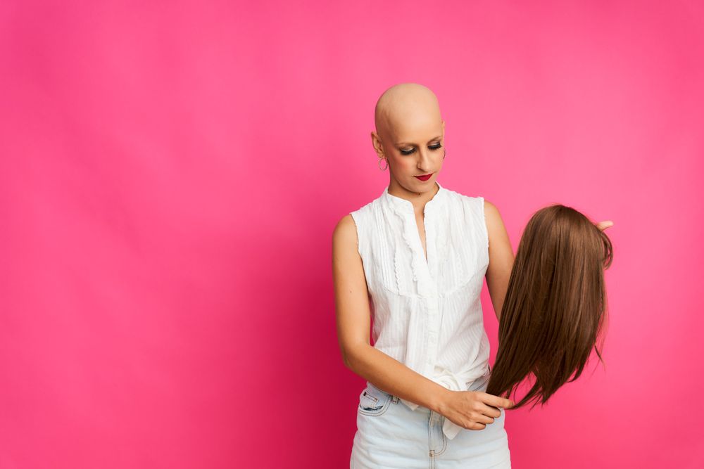 portrait of a woman suffering from breast cancer preparing the wig to cover her head without hair