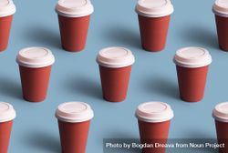 Three rows of disposable coffee cups on blue background 4ApWm5