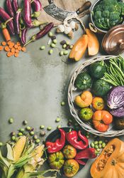 Fresh produce on concrete background, with thatched basket, halved squash, vertical composition