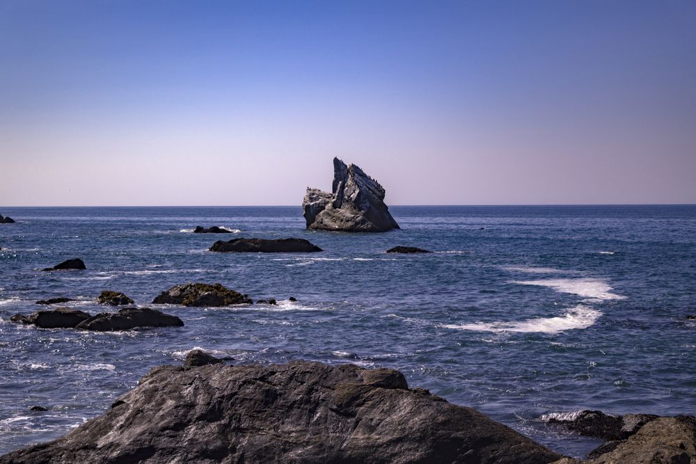 Rocks out in the Pacific Ocean under blue sky