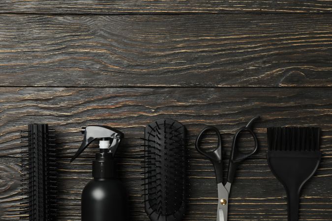 Flat lay with hairdresser accessories on wooden background, space for text