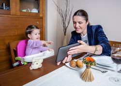Businesswoman mother and baby girl looking tablet