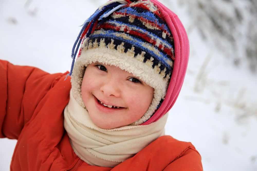 Happy child bundled up and playing in snow