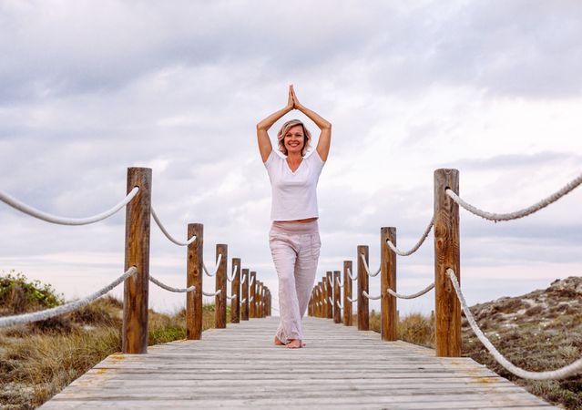 Cheerful woman exercising on timber path