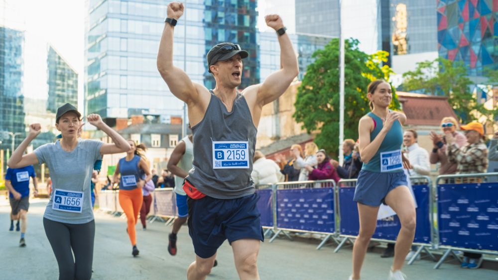 Portrait of Smiling  Man Running in a City Marathon, Waving at the Supportive Audience.
