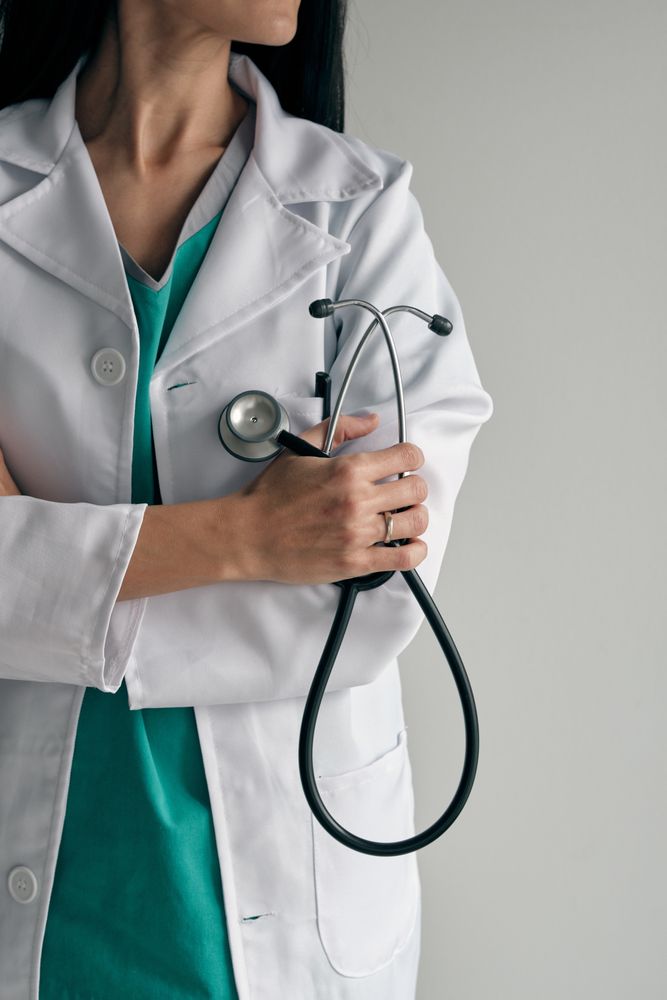 Crop confident physician with stethoscope and crossed arms