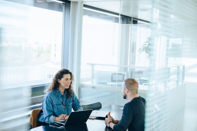 Businesswoman interviewing male job candidate in meeting room