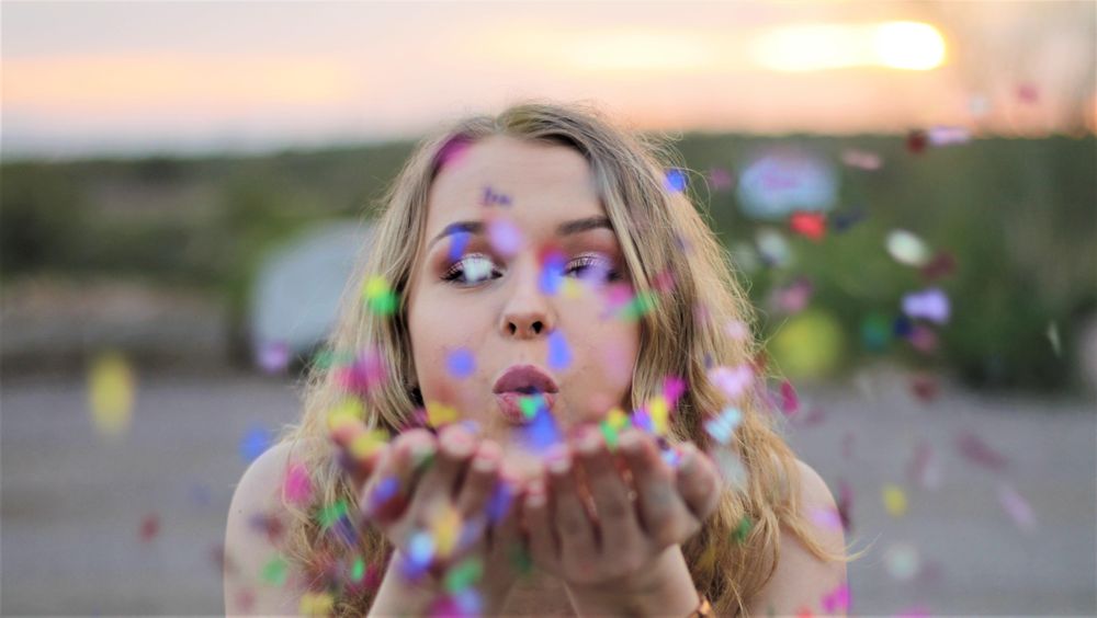 Woman blowing confetti outdoor