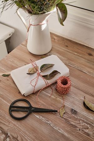 Wrapped gift box with scissors on table