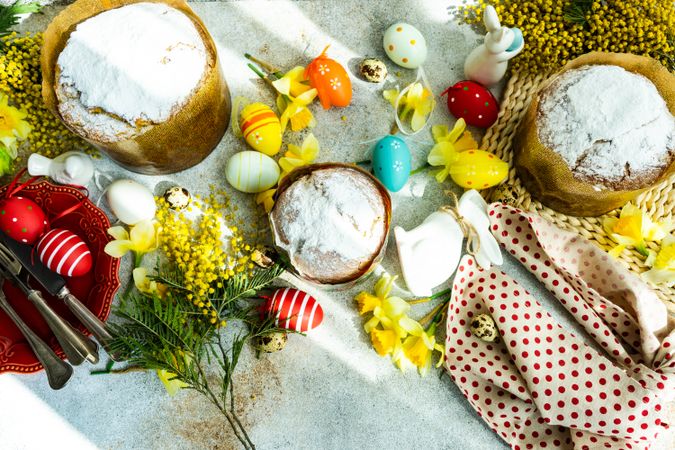 Top view of Easter food concept with dusted cakes, Easter eggs and spring flowers