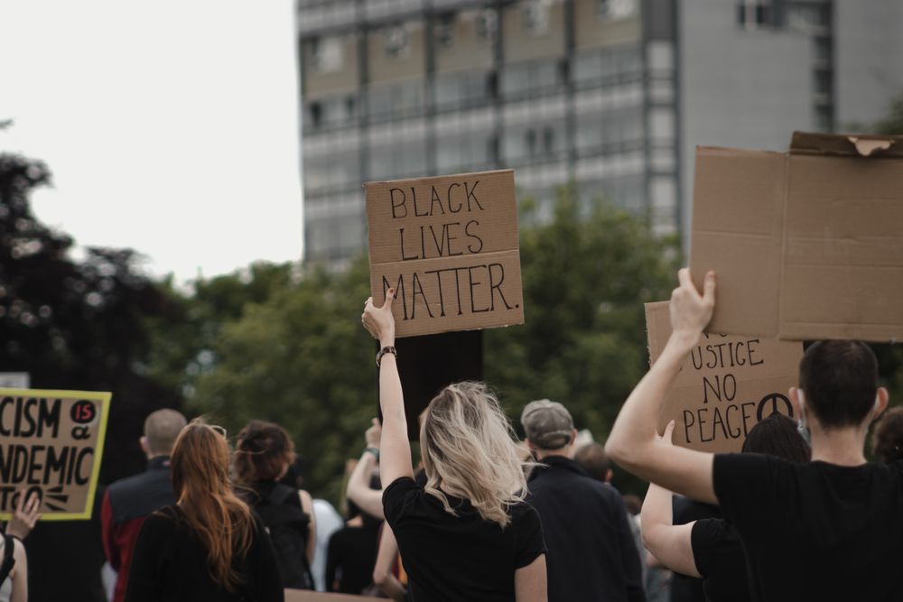 Woman holding Banner with words " Black Lives Matter"  at protest