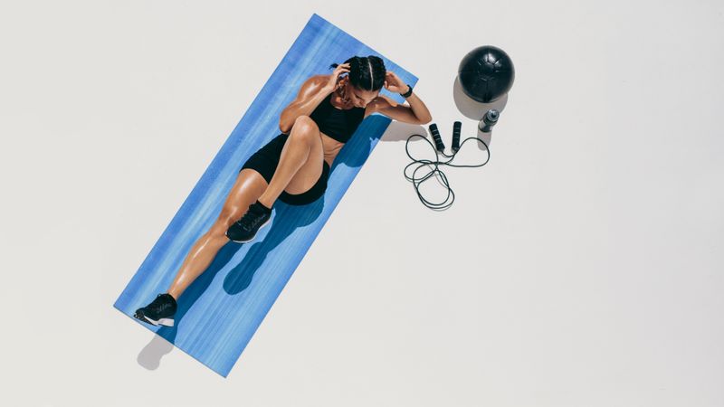Top view of a female athlete doing abdomen exercises