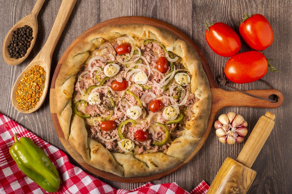 Wooden table with ingredients for pizza.