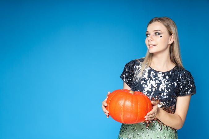 Concept of Halloween, young woman on blue background