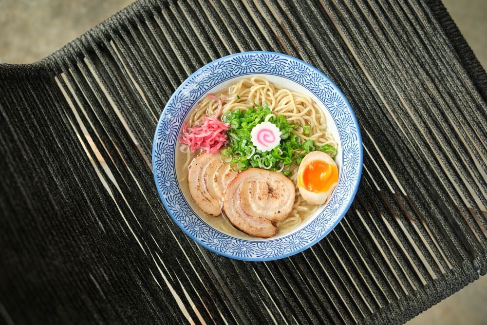 Delicious ramen soup with soft egg and pork meat in bowl