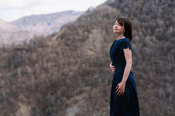 Woman in long blue dress standing in mountain