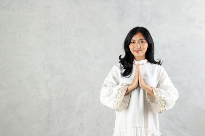 Female Asian Muslim Wearing Abaya Gesturing Eid Mubarak Greeting