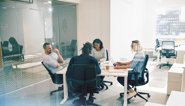 Multi-ethnic group of colleagues working around a table in a bright office