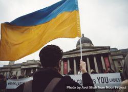 London, England, United Kingdom - March 5 2022: Man flying Ukraine flag in Trafalgar Square 56eNV0