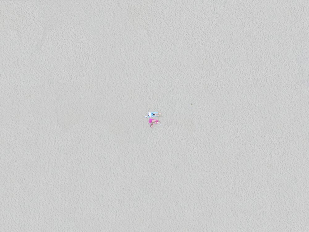 Top down view of friends relaxing on the beach.