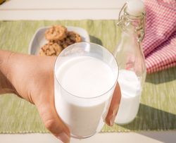 Glass of milk held in hand