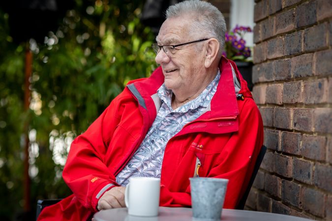 Calm and happy older man sitting with coffee mug